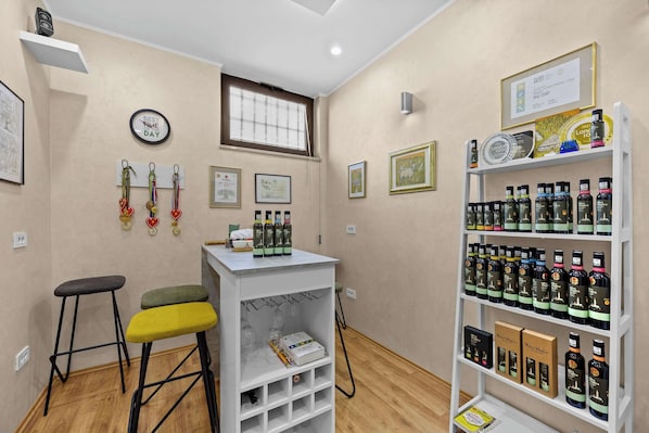 A room with a white bar stool, a shelf with framed certificates, and a wall-mounted clock.