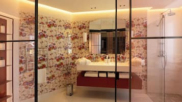 Un baño moderno con papel tapiz floral, una ducha con cerramiento de vidrio y un tocador con espejo.