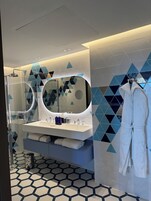 Un baño moderno con un espejo grande, lavamanos dobles y cabina de ducha de vidrio.