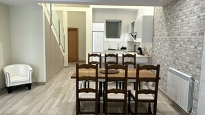 A modern kitchen with white cabinets, a built-in oven, and a large window.