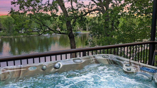 Un bain à remous avec vue sur un lac et des arbres.