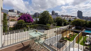 A rooftop terrace with a pool, seating areas, and a view of the city skyline. - Liiiving in Porto - Luxury Design Apartment M (Porto)