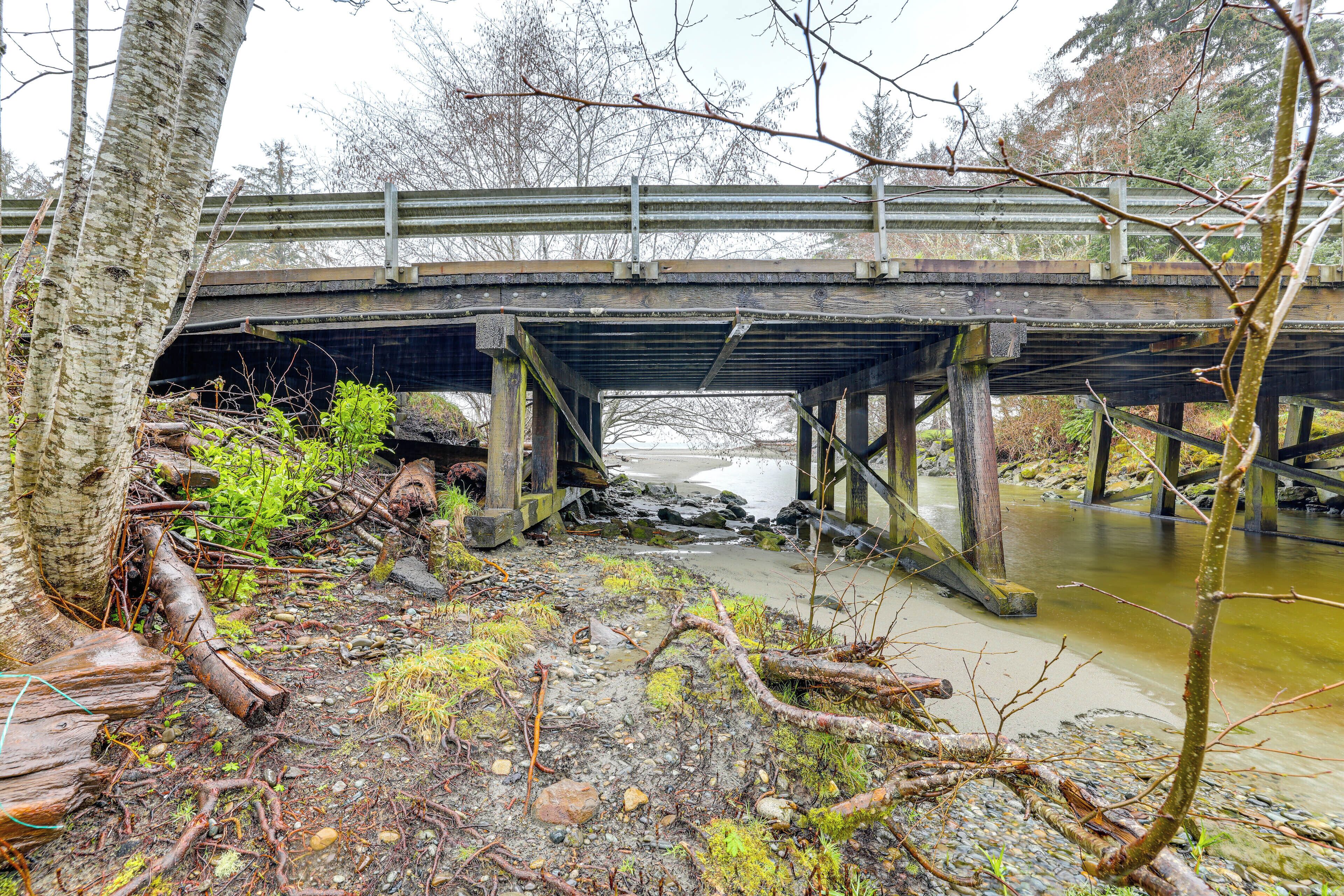 A wooden bridge over a river with a rocky and mossy ground.