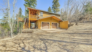A two-story house with a wooden deck, a garage, and a stone staircase. - 2 Mi to Dtwn: Cloudcroft Home w/ Furnished Deck (Cloudcroft)