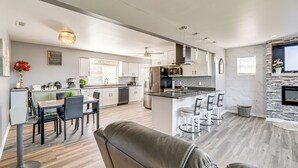 Une cuisine moderne dotée d’un îlot central, d’un coin repas avec des chaises et d’un espace de vie avec un canapé.