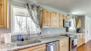 A kitchen with wooden cabinets, a stainless steel dishwasher, a microwave, and a stove.