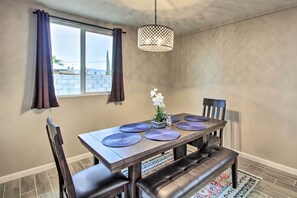 A dining area with a table set for four, featuring dark wood furniture and purple placemats. - Charming Home ~ 7 Mi to Downtown Tucson! (Tucson)