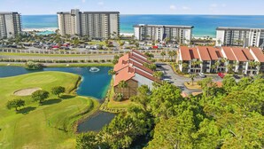 Un hôtel situé sur la côte, composé de plusieurs immeubles de grande hauteur, doté d’un terrain de golf et bordé par une étendue d’eau.