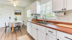 A kitchen with white cabinets, a wooden countertop, a sink, and a window with blinds. - 4 Mi to Dtwn: Dog-friendly Fayetteville Home (Fayetteville)