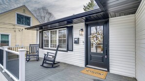 A house with a porch, a black door, and a welcome mat. - Screened Patio & Fire Pit: Modern Westerville Home (Westerville)
