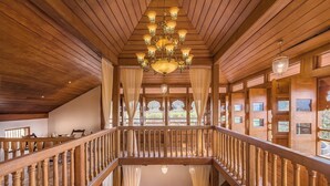 A wooden staircase with a railing, leading to a balcony with a view of greenery. - CosmicStays Parambi Farm- Vintage Charm  (Bhor)