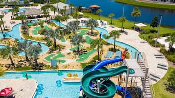 A water park with a large pool, a water slide, and a golf course.