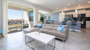 Un amplio salón con sofá, mesa de centro y vistas al exterior.