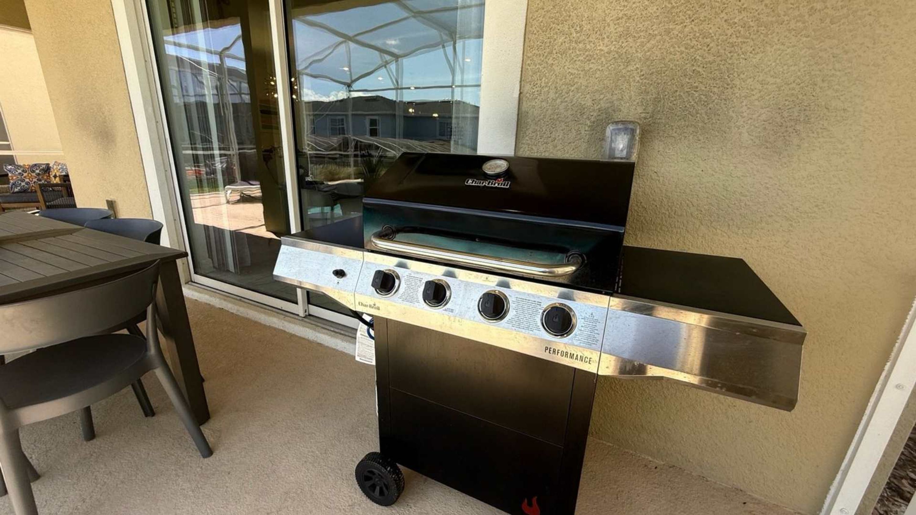 An outdoor grill with four burners, a chimney, and a control panel.