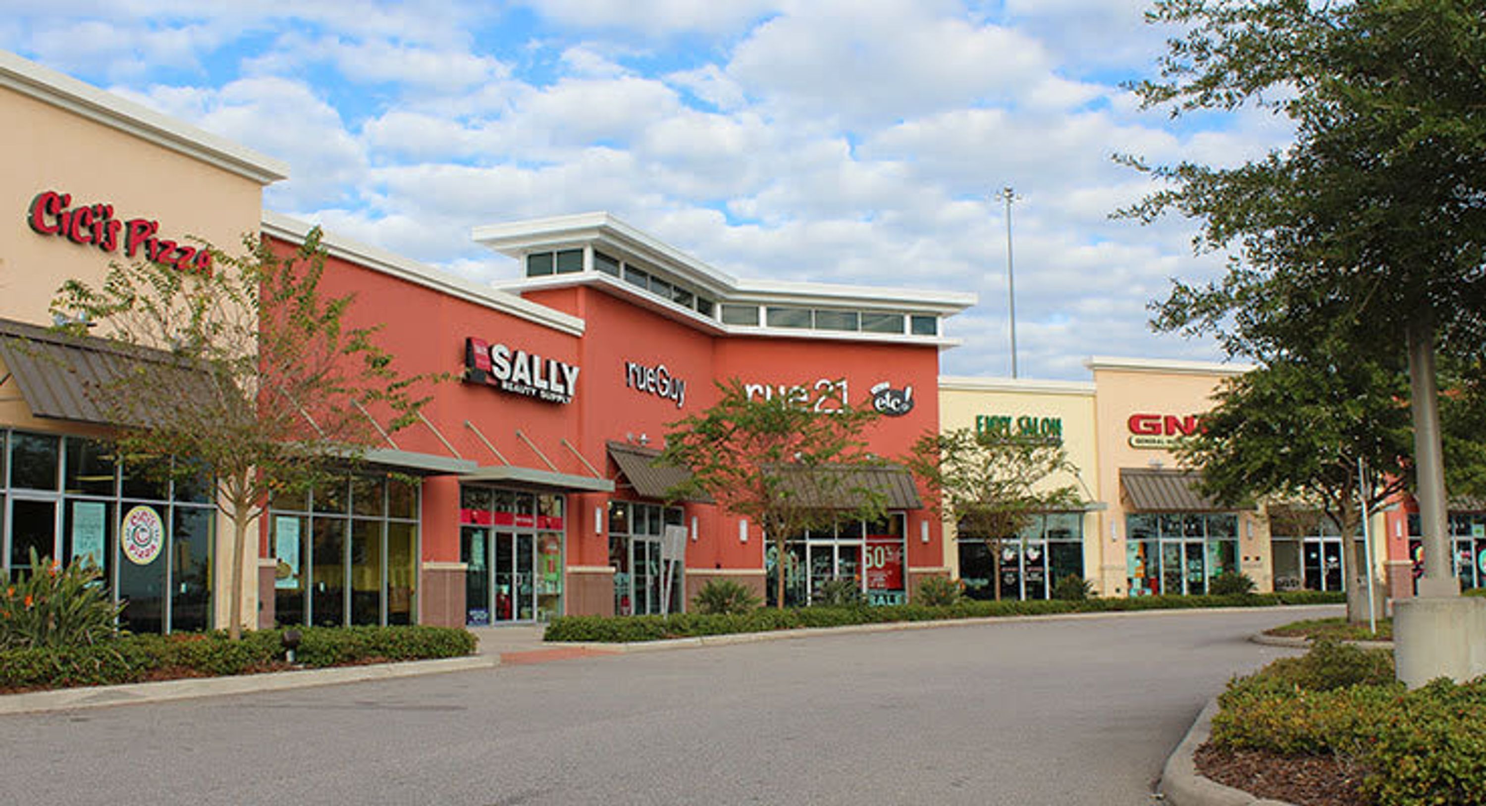 A shopping center with stores like Sally Beauty Supply, Ace Hardware, and Genuco.