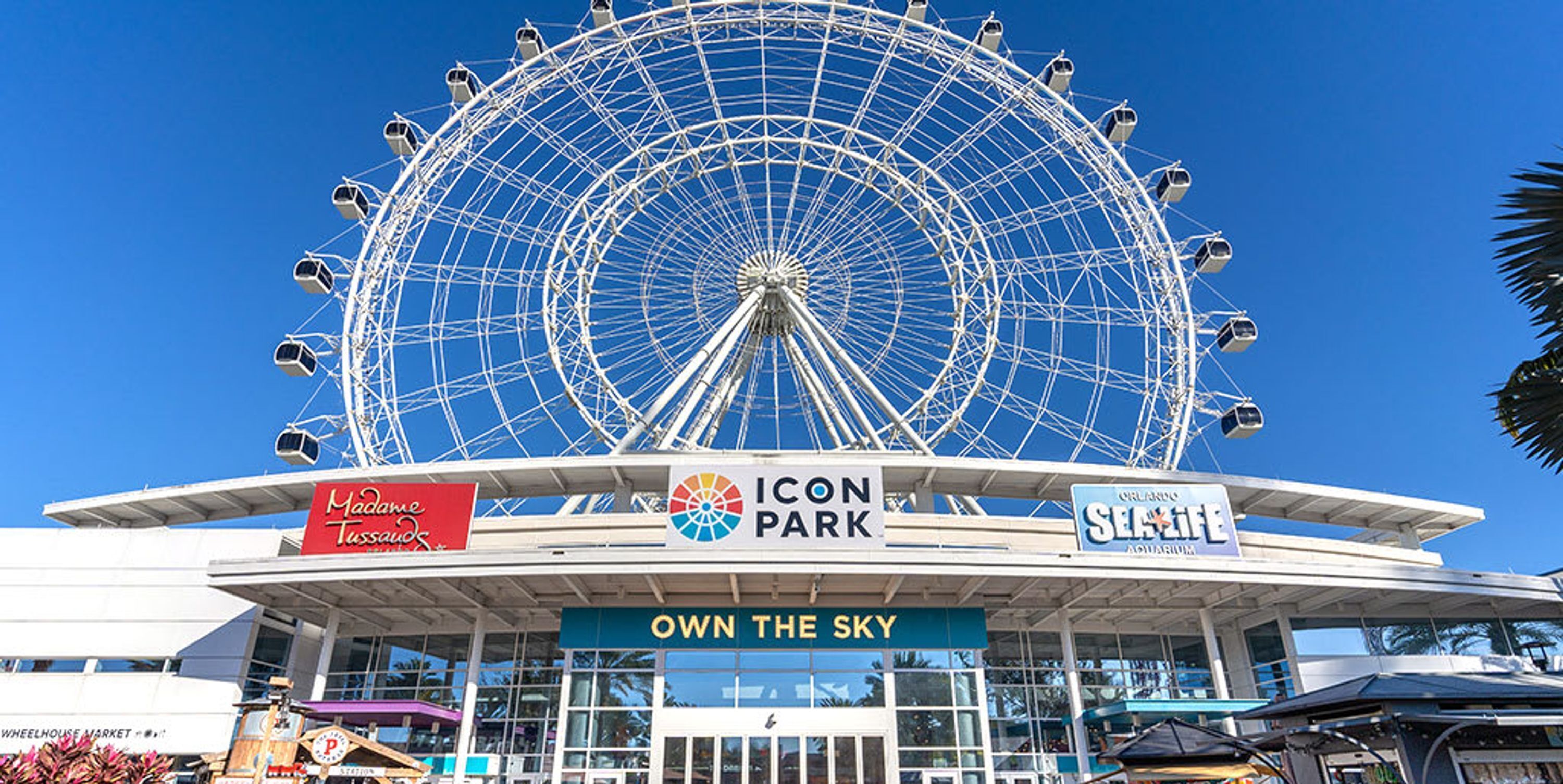 Une grande roue au parc ICON, avec une enseigne portant l'inscription « OWN THE SKY ».