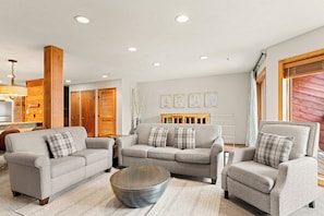 A living room with a grey sofa set, a round coffee table, and a wooden accent wall. - Center of Town, One Block From Main St. and Peak 9 (Breckenridge)