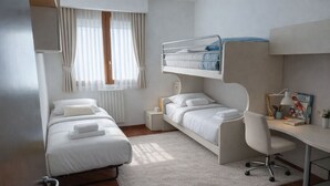Una habitación de hotel moderna con una litera, un escritorio y una silla.