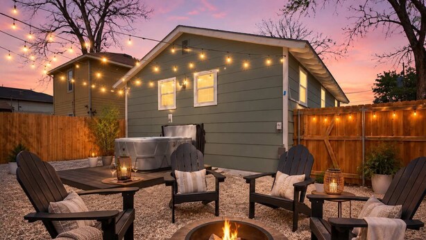 Un jardin avec un espace salon extérieur, un jacuzzi et un foyer.