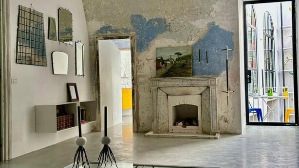 A modern interior with a glass table, a fireplace, and abstract wall art. - Capri Kronos Design Suites (Anacapri)
