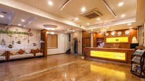 A hotel lobby with a reception desk, a sofa area, and a staircase leading to the upper floors. - W Hotel Shamshabad Hyderabad Airport (Hyderabad)