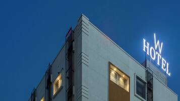 Un edificio con un cartel que dice "W HOTEL" contra un cielo al anochecer.