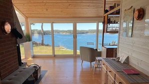 A spacious room with a large sliding glass door leading to a lakeside view. - 4 Star Holiday Home in Stromstad (Stromstad)