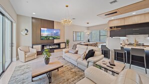 A modern living room with a fireplace, sofa, and TV. - Uptown Oasis 3 Bedroom Townhouse (Sarasota)