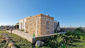 A stone house with a patio, outdoor seating, and a small staircase leading to an upper level. - Tenuta alle Macchie, swimming pool, 4 guests, two bedrooms (Racale)