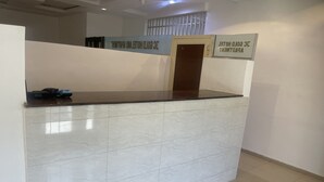 Un mostrador de recepción con encimera de mármol y un letrero que indica un hotel de estándar oro.
