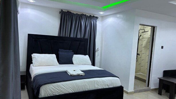 Un dormitorio moderno con cama, cortinas y una puerta.