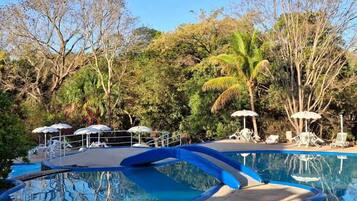 Een binnenzwembad, 3 buitenzwembaden en parasols bij het zwembad