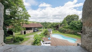 A backyard with a swimming pool, a barbecue area, and a stone house. - Les Combes de Testas: Accommodation for 24 people, swimming pool, Aveyron Gorges (Sanvensa)