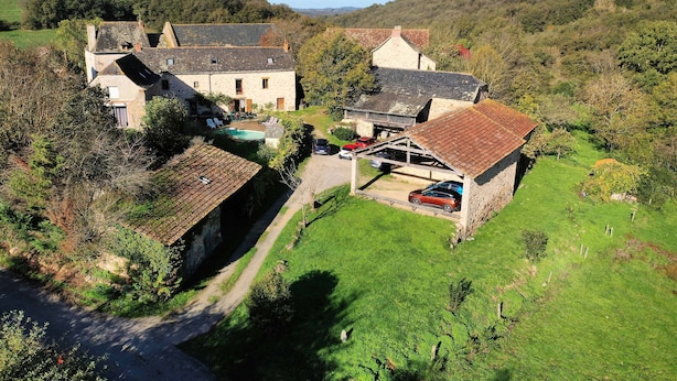 A rural property with stone buildings, a swimming pool, and a red car parked outside. - Les Combes de Testas: Accommodation for 24 people, swimming pool, Aveyron Gorges (Sanvensa)