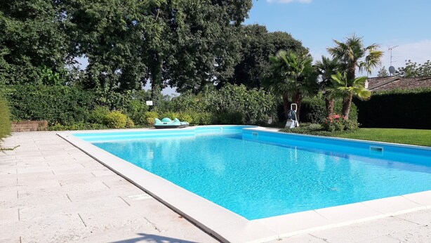 A rectangular swimming pool with a tiled edge, surrounded by a paved patio. - Casa Rondinella By Case al Lago (Cavriana)