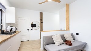 Una cocina moderna con encimera de madera y estufa integrada. Se observa una puerta blanca que da a otra habitación.