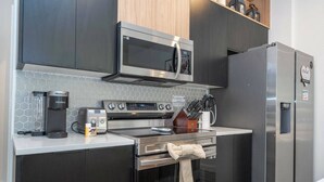 Una cocina moderna con microondas, cafetera y refrigerador.
