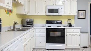 A kitchen with white cabinets, a microwave, a stove, and a dishwasher. - Coastal Comfort, Almost Oceanfront Duplex in Salter Path, NC! (Salter Path)