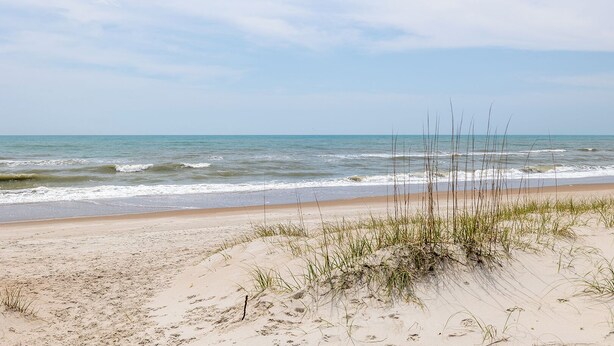 A beach with sand dunes and sparse vegetation. - Coastal Comfort, Almost Oceanfront Duplex in Salter Path, NC! (Salter Path)