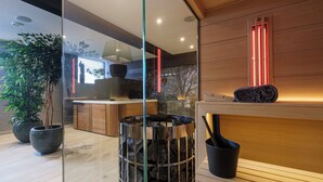 A modern interior with a wooden bench, a glass partition, and a stone fireplace. - Relax in Wellness Room with Sauna and Spa Bath and luxurious outdoor seating. (Nieuwe Niedorp)