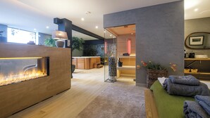 A modern spa area with a wooden reception desk, a glass partition, and a relaxation area with towels. - Relax in Wellness Room with Sauna and Spa Bath and luxurious outdoor seating. (Nieuwe Niedorp)