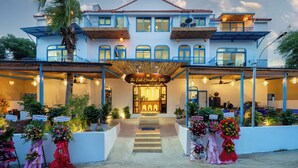 A hotel with a welcoming entrance, multiple balconies, and a covered area with plants. - The Linh Coastline Villa (Da Nang)