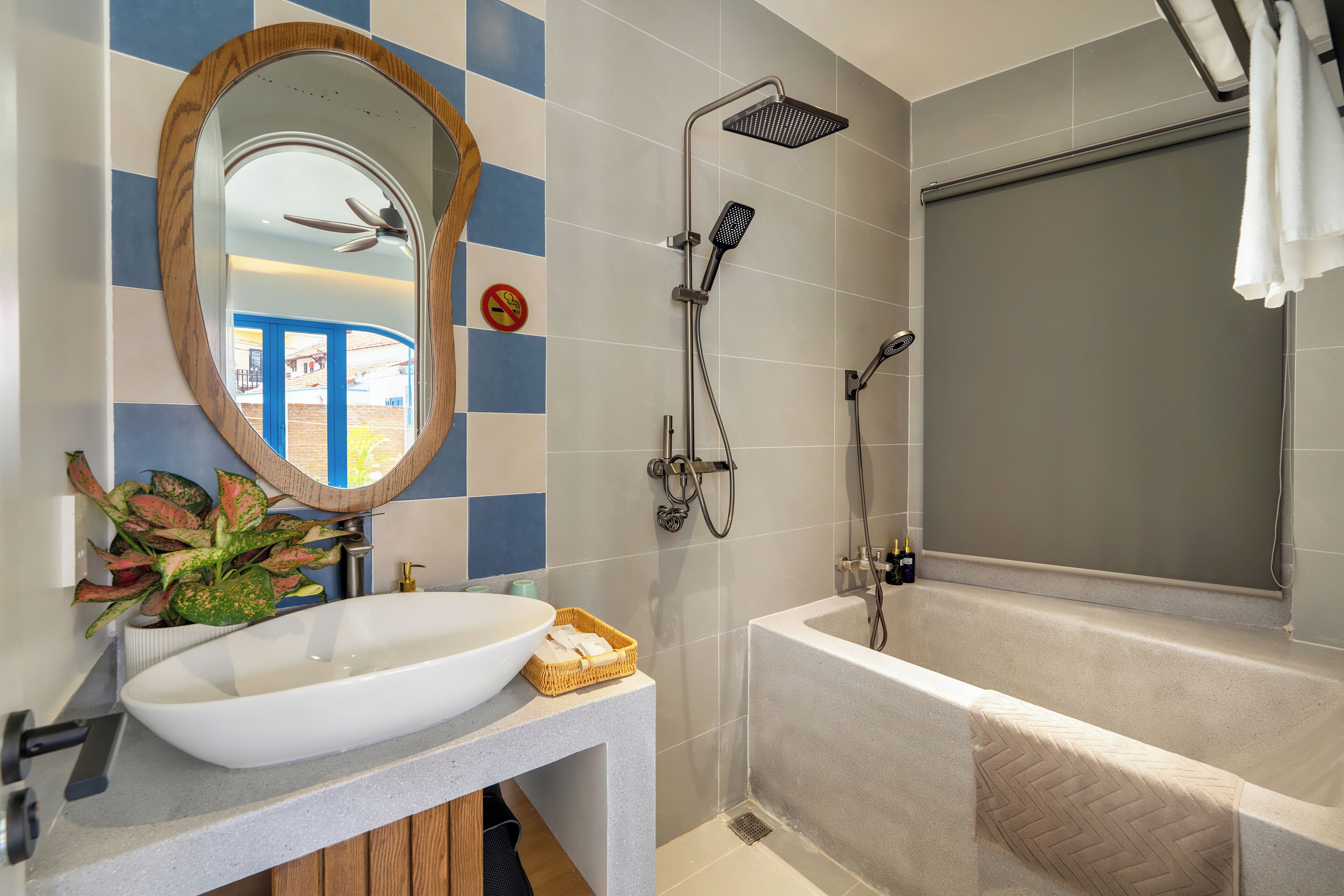 A bathroom with a white sink, a large mirror, a shower with a handheld showerhead, and a bathtub.