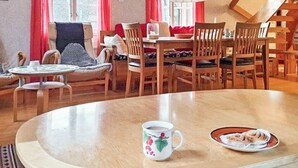 A cozy dining area with a round table, chairs, and a coffee cup. - 4 Star Holiday Home in Orno (Orno)