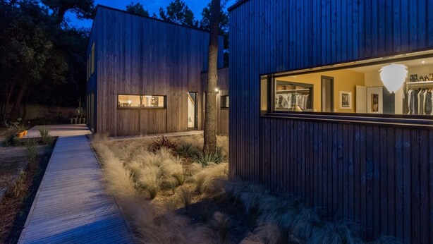 Un bâtiment moderne doté de grandes fenêtres et d’une façade en bois.