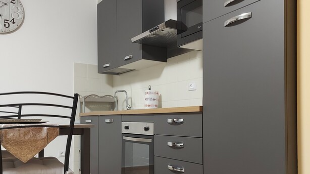 A modern kitchen with grey cabinets, a built-in oven, and a microwave. - Apartment in the Orti area near the University (Alessandria)