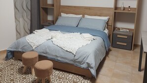 A bedroom with a bed, two nightstands, a wardrobe, a patterned rug, and an air conditioning unit. - Apartment in the Orti area near the University (Alessandria)