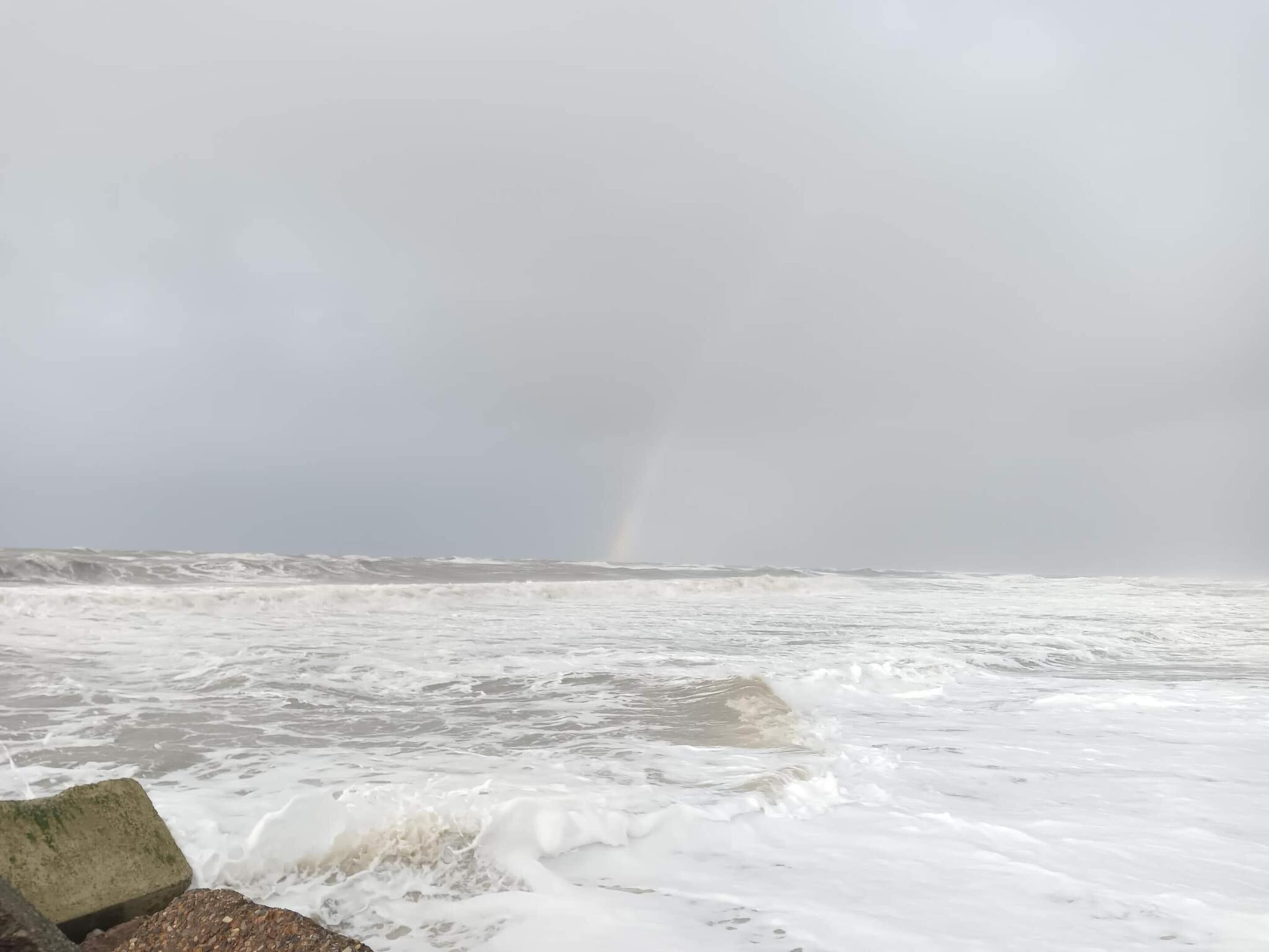 A stormy sea with waves crashing against rocks.