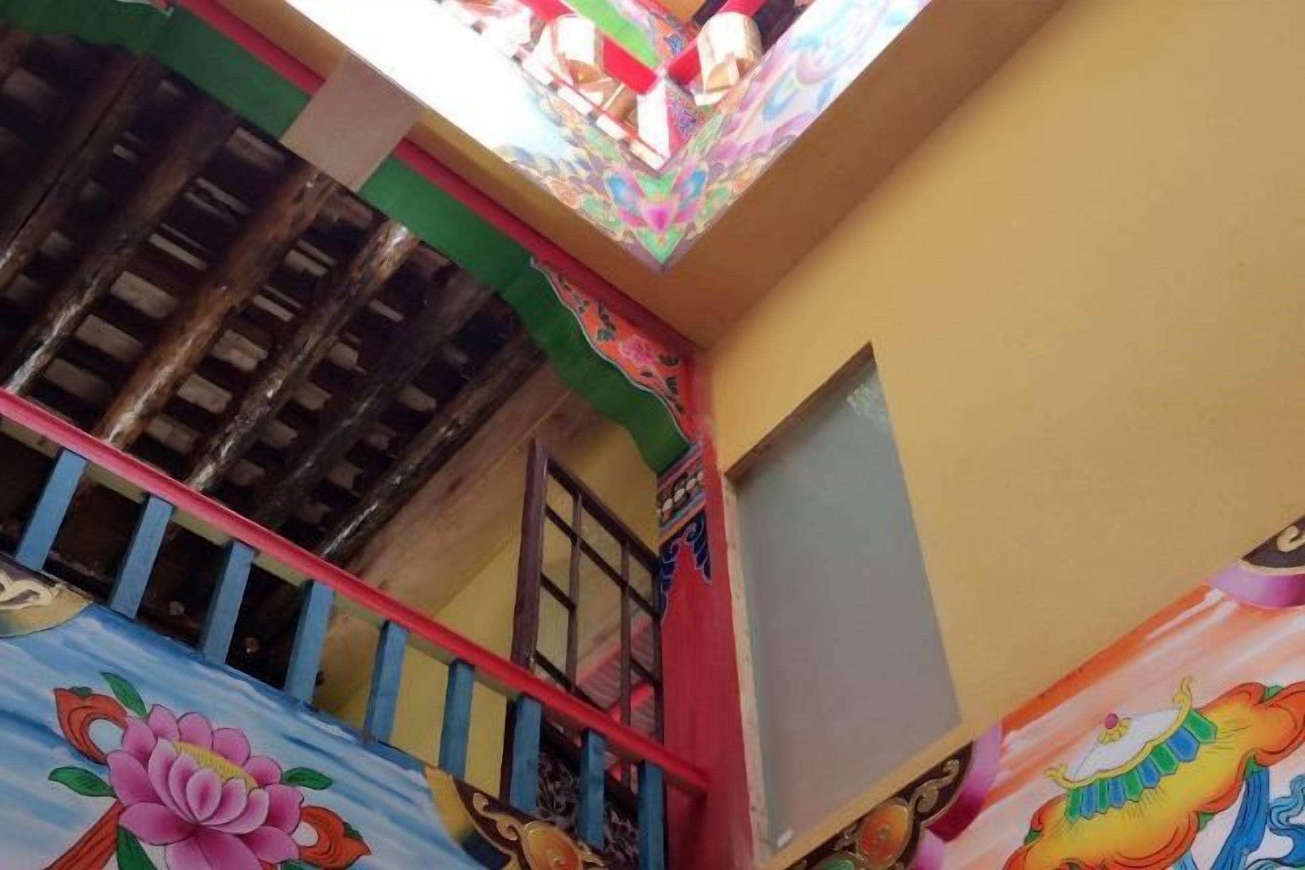 Una scala con un murale colorato, un soffitto in legno e una finestra.
