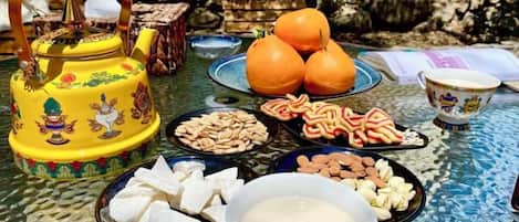 Una mesa con diferentes alimentos y una tetera amarilla decorativa.